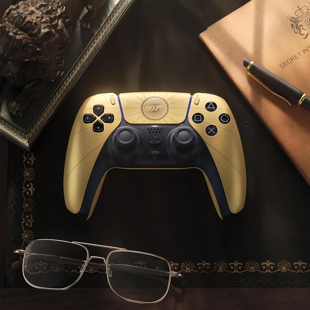 007 First Light gold DualSense controller styled on a desk